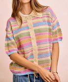 Person wearing a colorful striped sweater with a plain background