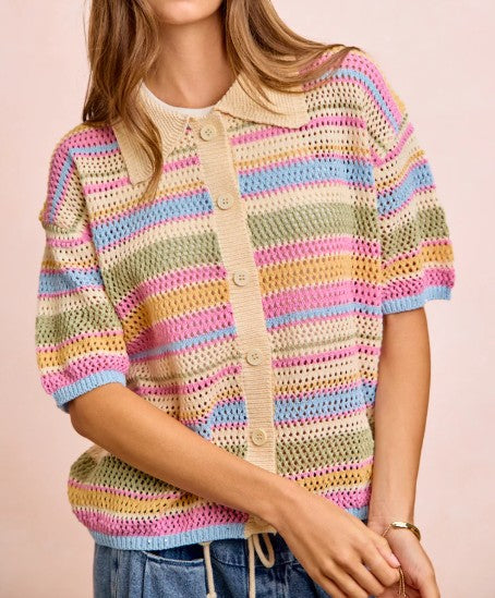 Person wearing a colorful striped sweater with a plain background
