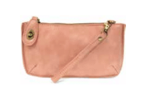 Pink leather clutch bag with a strap on a white background