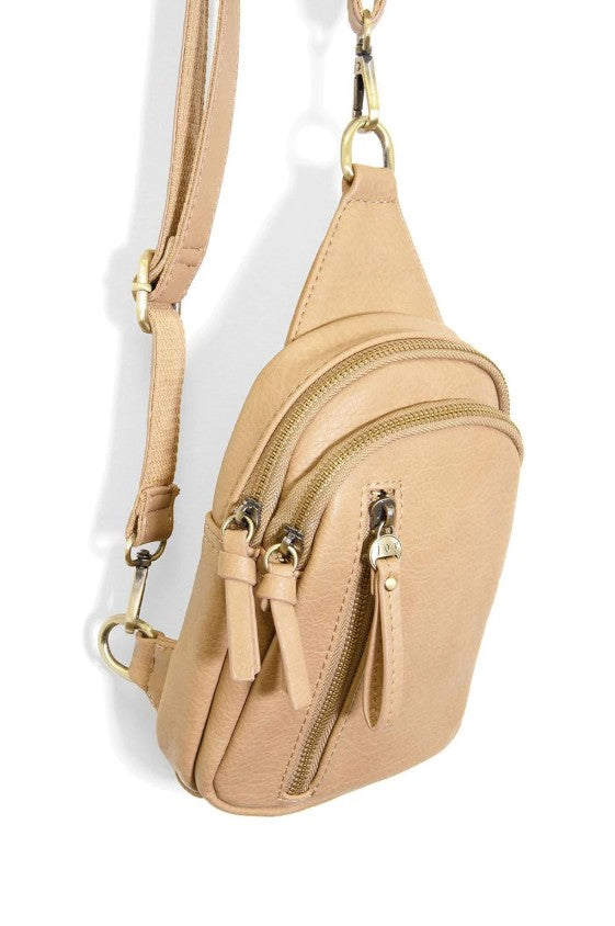 Beige crossbody bag with gold zippers on a white background