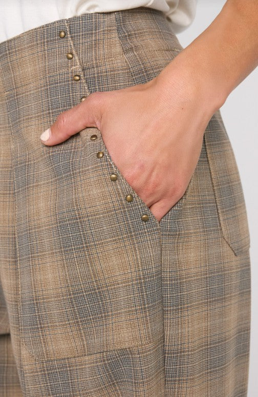 Close-up of plaid pants with a hand in the pocket on a white background