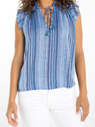 Woman wearing a blue striped sleeveless top with tassel details 