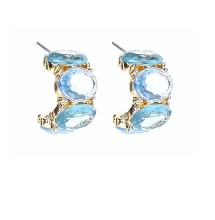 Pair of earrings with blue gemstones and gold accents on a white background