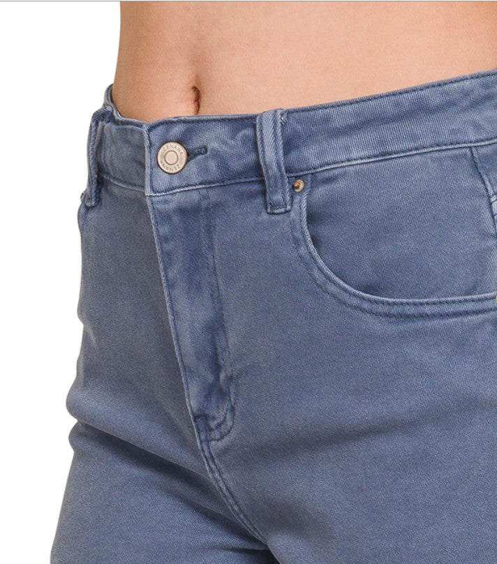 Close-up of blue jeans with a button and zipper on a white background