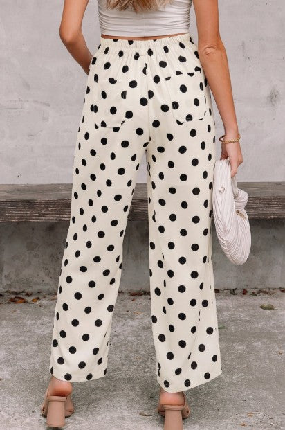 Person wearing polka dot pants with a neutral background