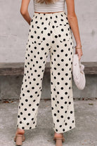 Person wearing polka dot pants with a neutral background