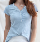 Light blue short-sleeve shirt worn by a person on a white background