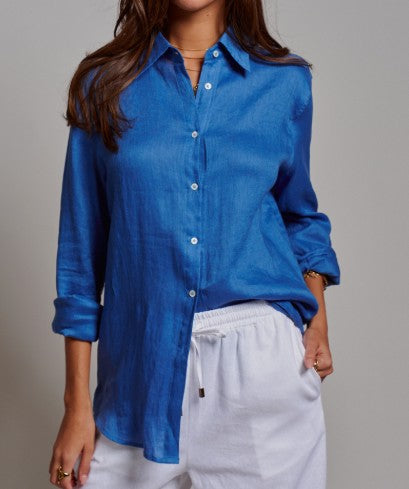 Person wearing a blue shirt and white pants against a gray background