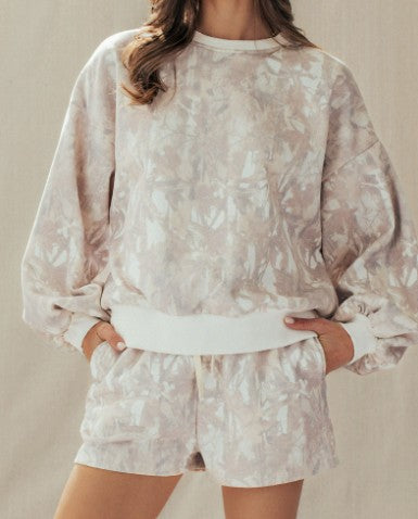 Person wearing a light-colored camo outfit with a plain background