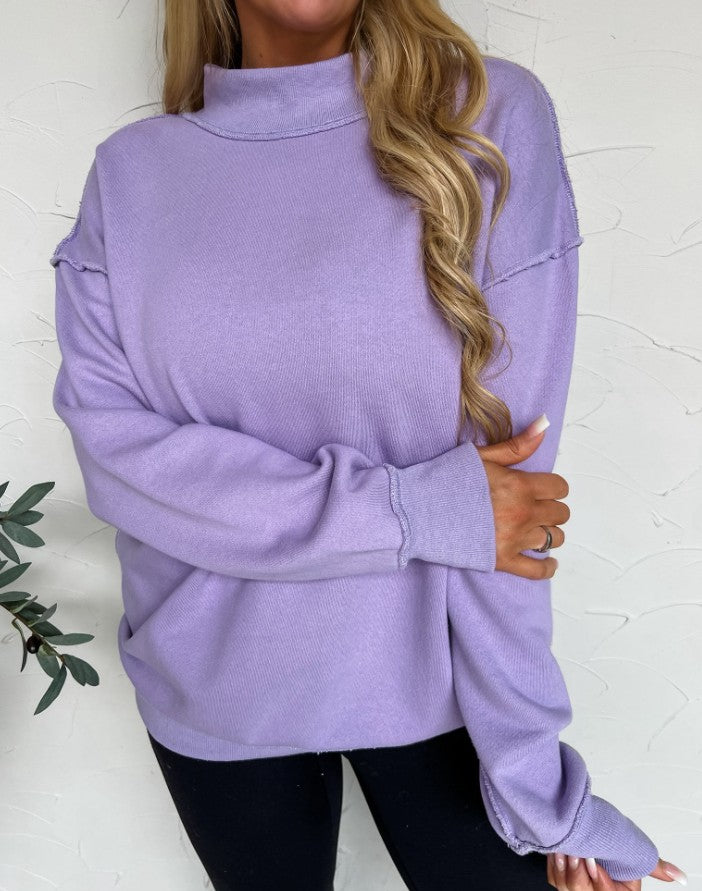 Person wearing a purple sweater against a white background
