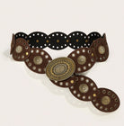 A western-style belt with dark brown leather panels, silver-tone metal studs, and a large ornate oval buckle in an antique gold/bronze finish, displayed on a light beige background.