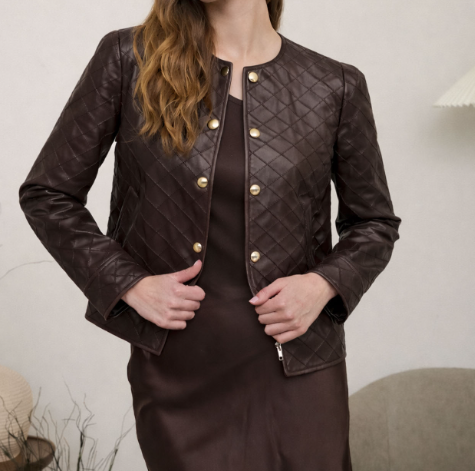 A woman wearing a dark brown quilted faux-leather jacket with gold-tone buttons over a matching dark brown dress, shown from the neck down in an indoor setting.