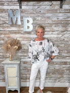 Woman standing in front of a wooden wall with decorative letters 'MB'.